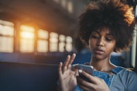 a young woman on a train looking at her phone